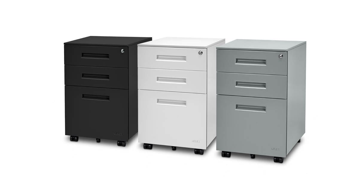 Three UPLIFT 3-drawer file cabinets side by side on white, one black, one white and one gray, each with a top-drawer key lock, recessed handles and small black casters