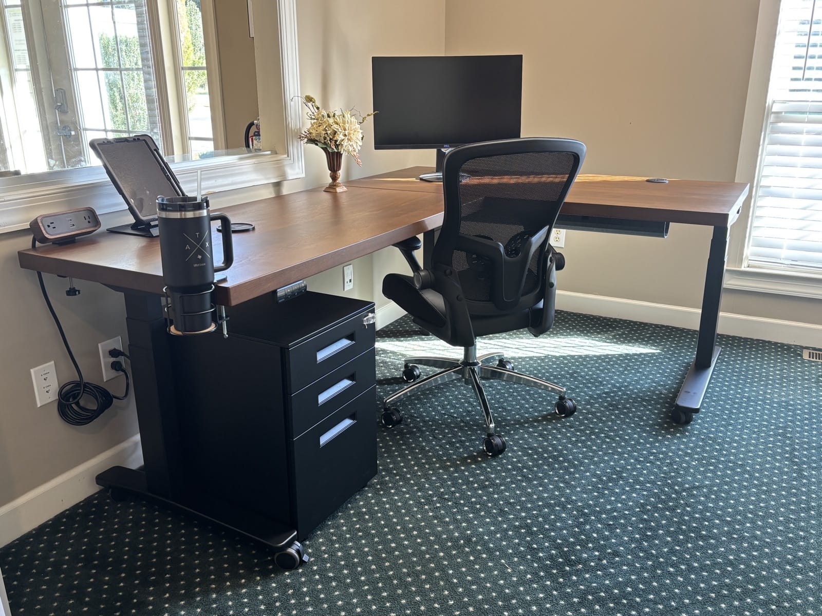 Black UPLIFT file cabinet under a walnut L-shaped reception desk at a tax office front counter